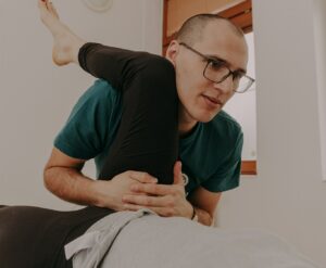 Fyzioterapeut Peter Štalmach pomocou manuálnych techník úľavuje dospelímu pacientovi bolesti bedrového kĺbu.